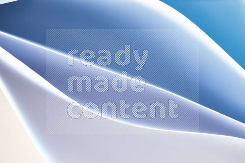 هذه الصورة تعرض تكوين فن الورق التجريدي مع منحنيات ورقية بتدرجات اللون الأزرق والأبيض المكونه بواسطة الضوء الملون