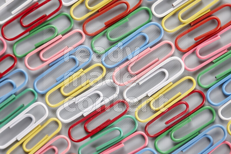 Multicolored paper clips isolated on a grey background
