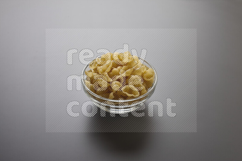 Snails pasta in a glass bowl on grey background