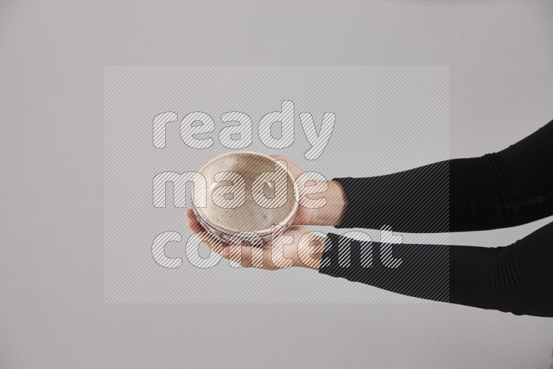 A woman in black abaya holding different pottery essentials in different positions