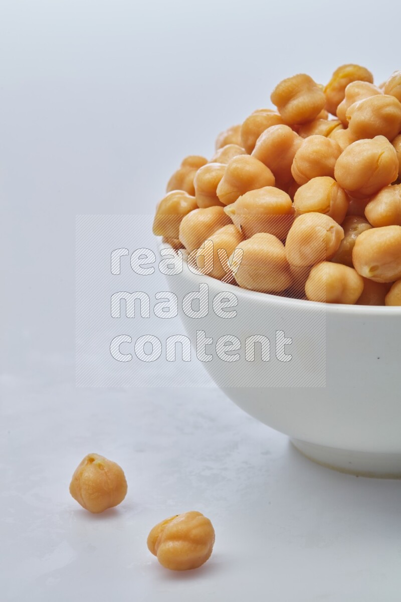 Close up shot of boiled chickpeas in a container on white background