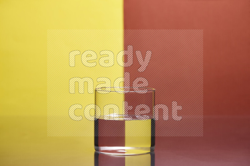 The image features a clear glassware filled with water, set against yellow and dark orange background