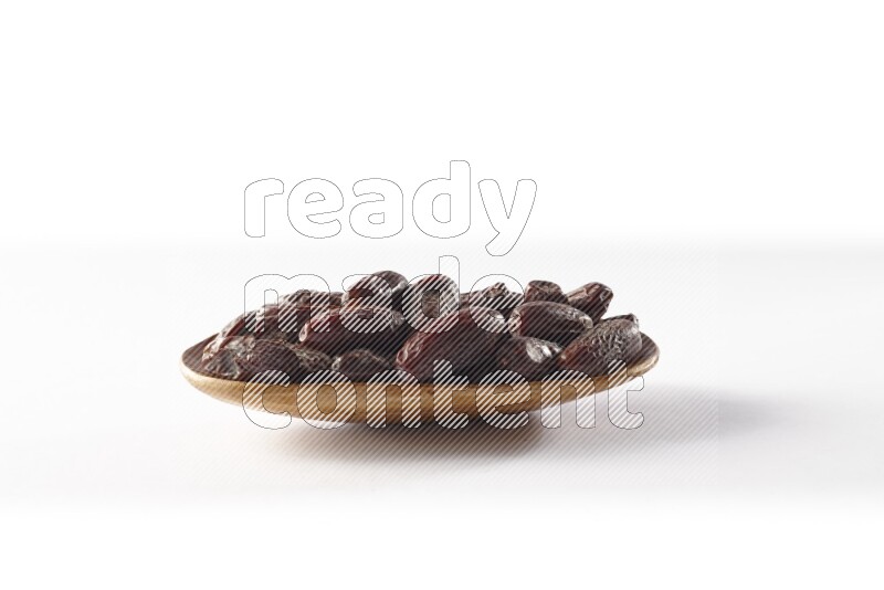 Dates in a wooden plate on white background