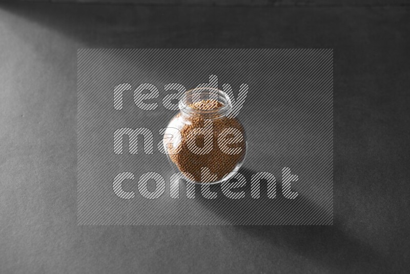 حبوب الخردل في وعاء زجاجي علي خلفية سوداء