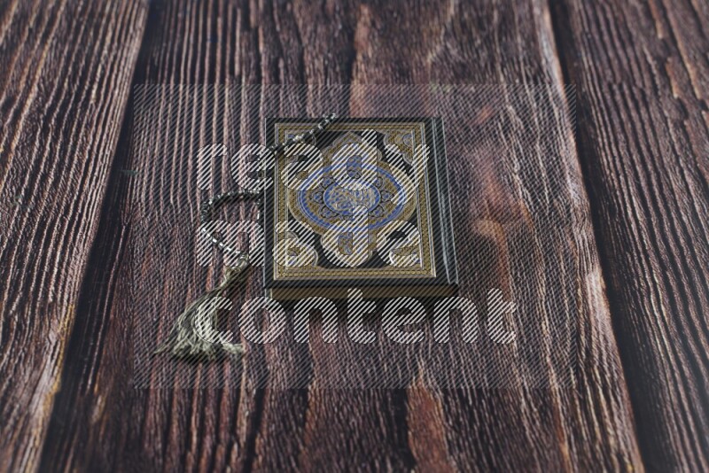 Quran with a prayer beads on wooden background