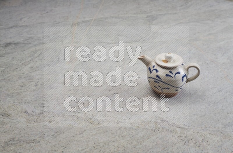 A pottery teapot on grey marble background