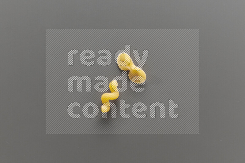 Twist pasta with other types of pasta on grey background