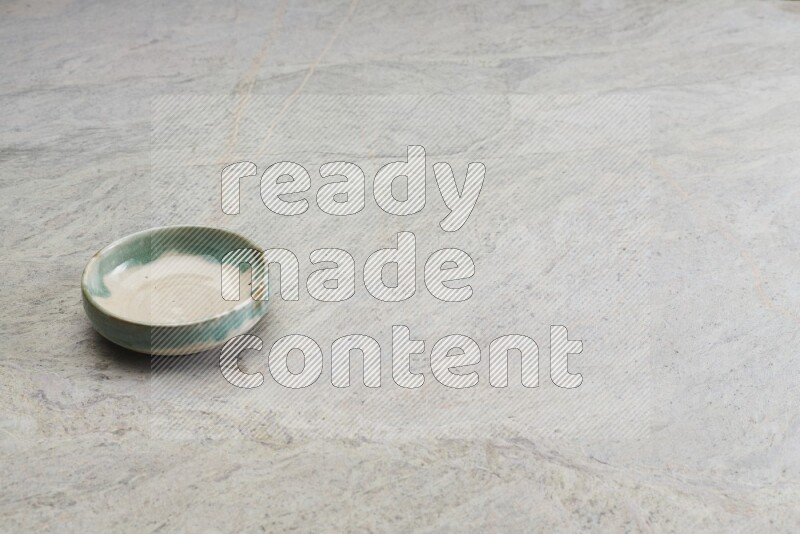 A multicolored pottery bowl on grey marble background