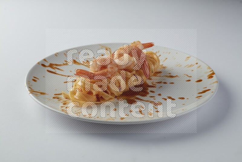 Fettuccini red sauce pasta with shrimp in a white plate on a white background