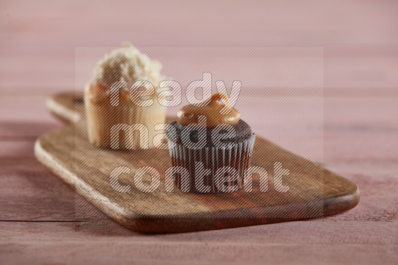 Chocolate mini cupcake topped with peanut butter on a wooden board