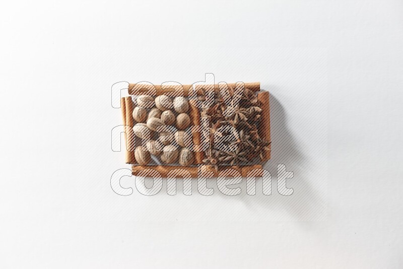 2 squares of cinnamon sticks full of star anise and nutmeg on white flooring