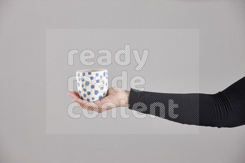 A woman in black abaya holding different pottery essentials in different positions