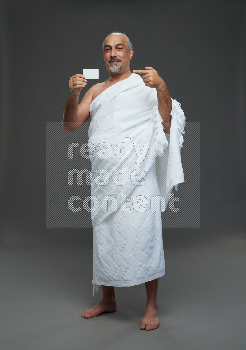 A man wearing Ehram Standing holding ATM card on gray background