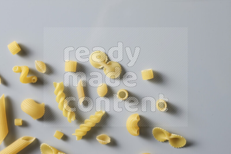 Different pasta types on light blue background