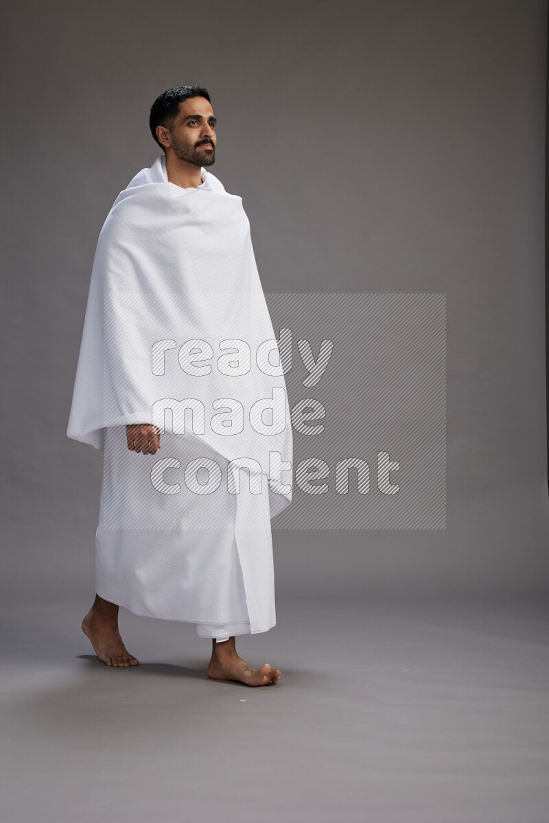 A man wearing Ehram Standing Interacting with the camera on gray background