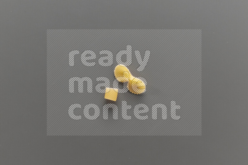 Big rings pasta with other types of pasta on grey background