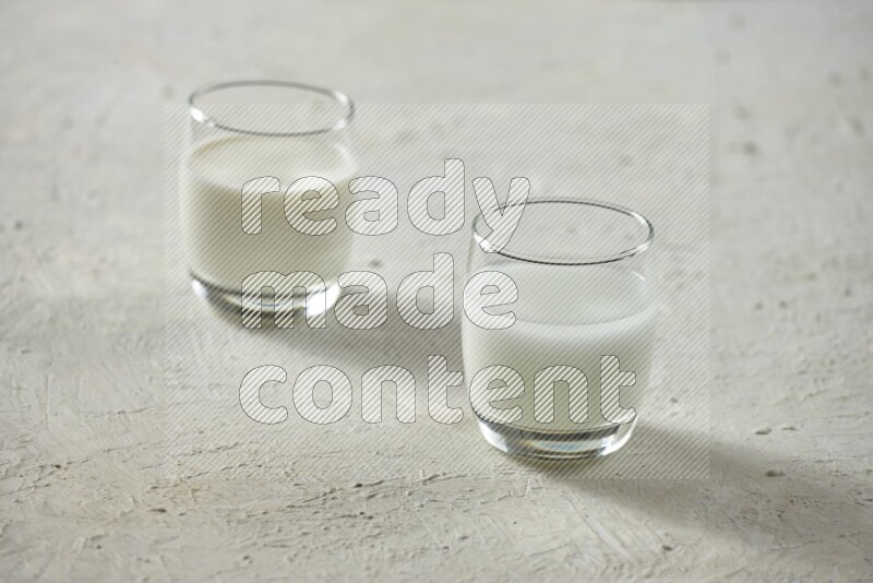 Cold drinks in a glass cup such as water, tamarind, qamar eldin, sobia, milk and hibiscus on textured white background
