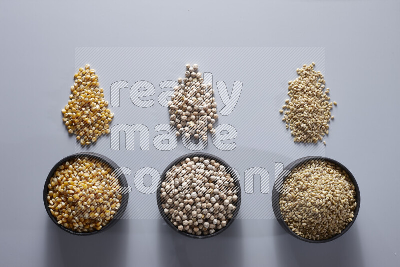 Legumes in pottery bowls on light grey background