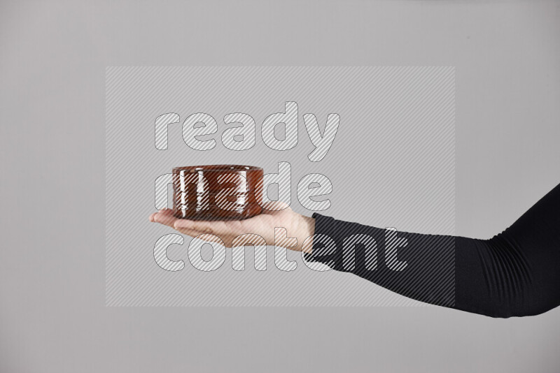 A woman in black abaya holding different pottery essentials in different positions