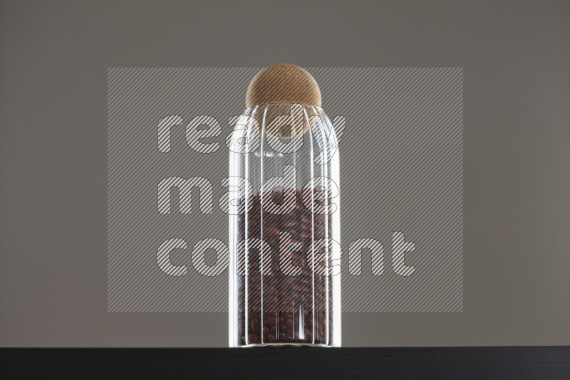 Red kidney beans in a glass jar on black background