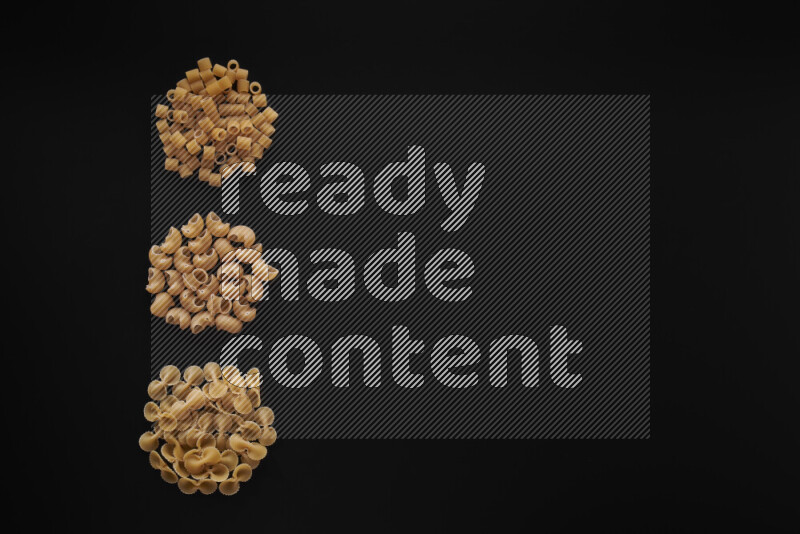 Different pasta types in 3 bunches on black background