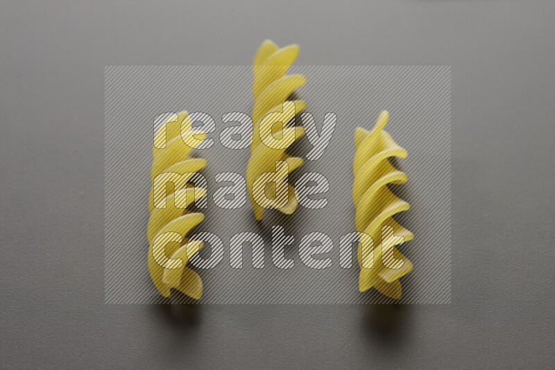 Fusilli pasta on grey background