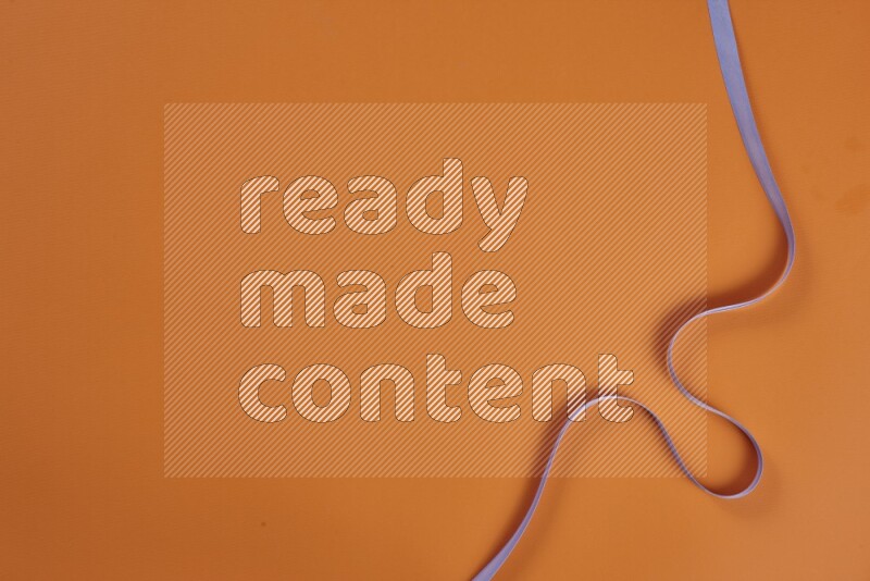 مجموعة من أدوات الخياطة والتفصيل أرجوانية اللون على خلفية برتقالية