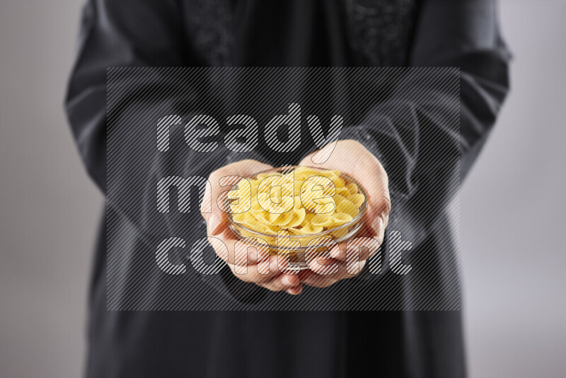 Woman in abaya holding different kinds of pasta in different positions