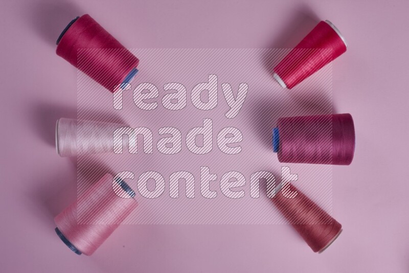 A pink collection of sewing and tailoring tools arranged on a pink background