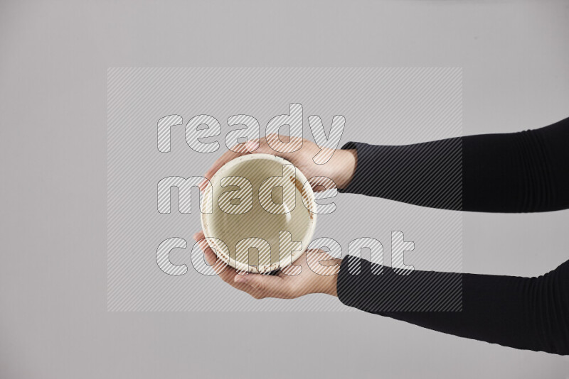 A woman in black abaya holding different pottery essentials in different positions