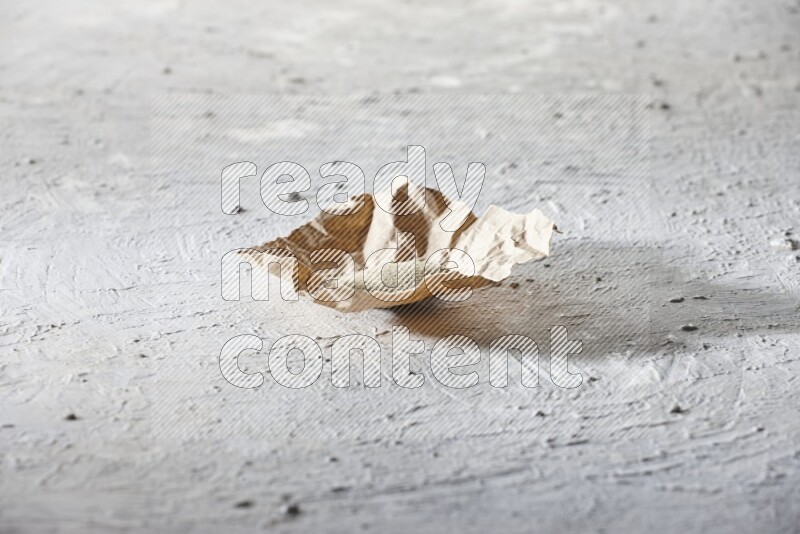White pepper powder in a crumpled piece of paper on textured white flooring