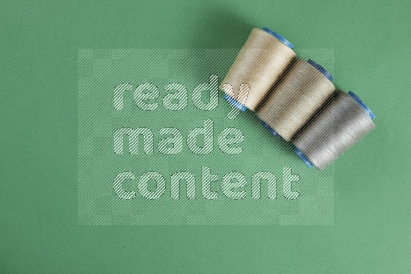 مجموعة من أدوات الخياطة والتفصيل بنية اللون على خلفية خضراء