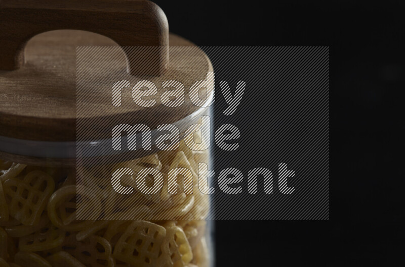 تسالي في وعاء زجاجي على خلفية سوداء