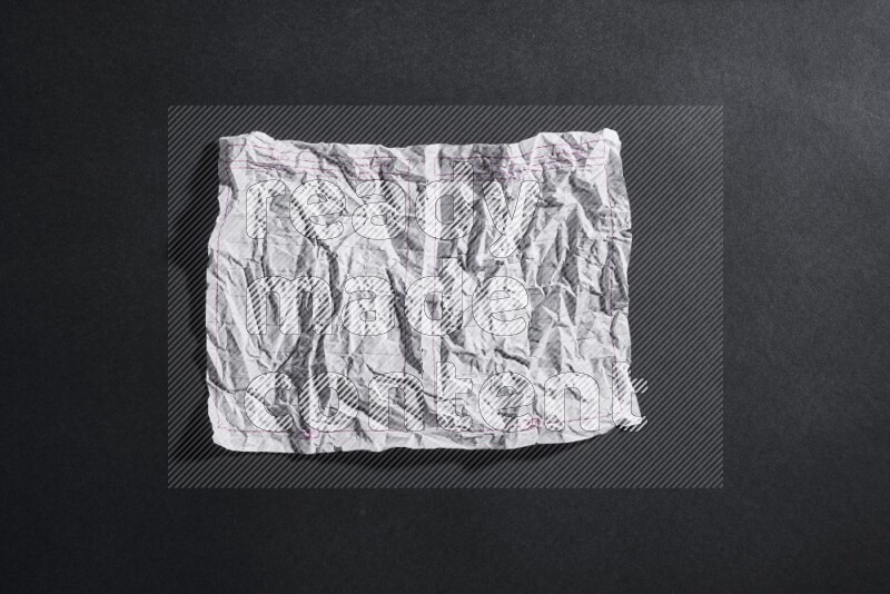 Crumpled notebook sheet on black background