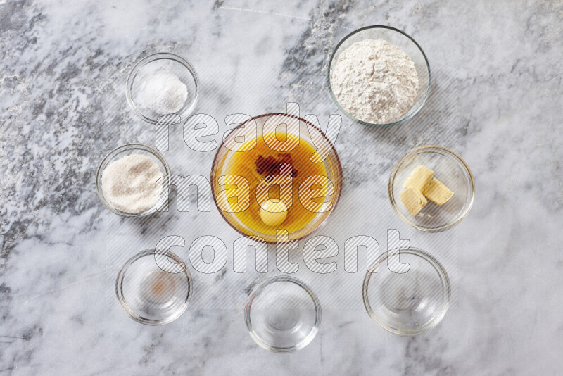 Cookies step by step with its ingredient, flour, butter, brown sugar, egg, vanilla extract, white sugar, chocolate chips and baking soda on grey marble background