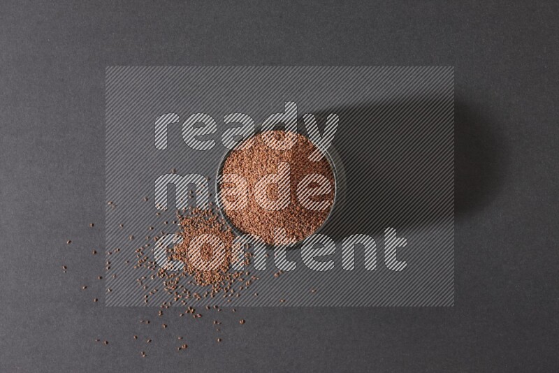 وعاء فخاري أسود ممتلئ ببذور حب الرشاد على أرضية سوداء