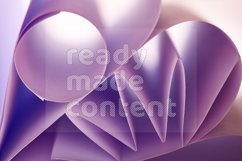 An artistic display of paper folds creating a harmonious blend of geometric shapes, highlighted by soft lighting in purple tones