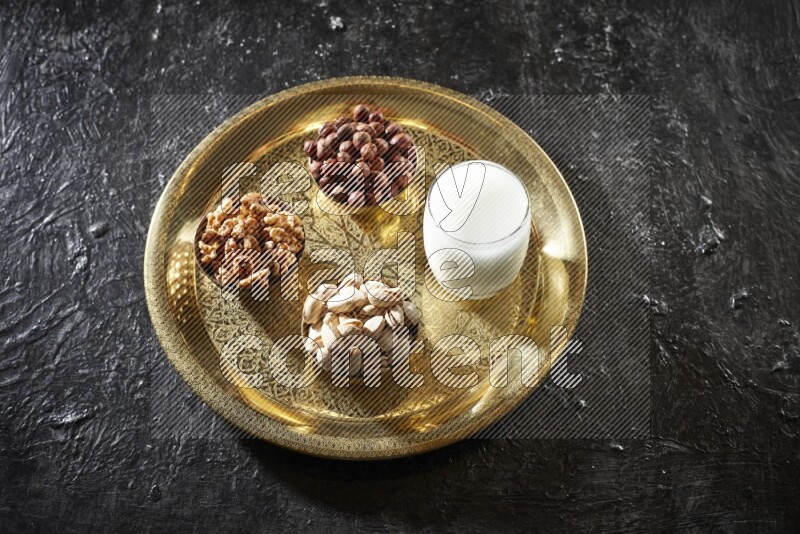 Nuts in metal bowls with sobya on a tray in dark setup