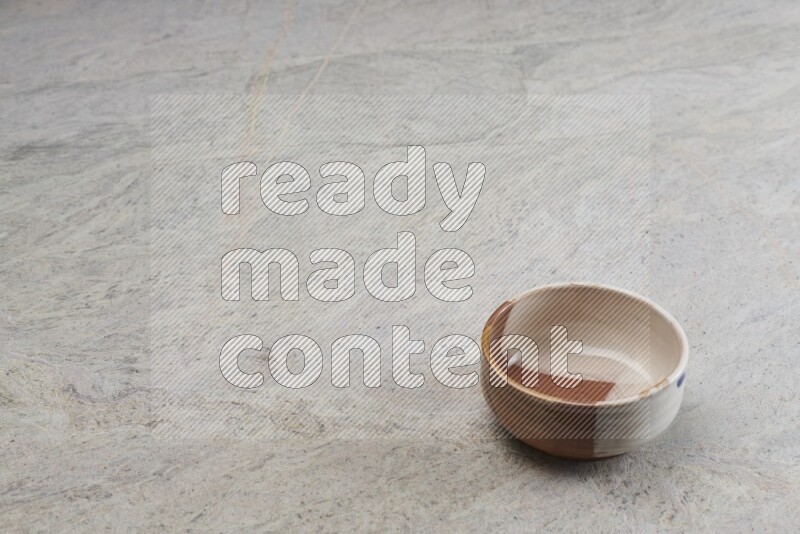 A multicolored pottery bowl on grey marble background