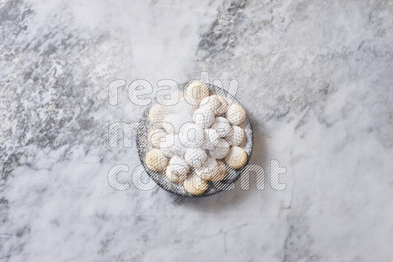 Kahk in black pottery plate on grey marble background