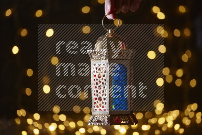 A traditional ramadan lantern surrounded by glowing fairy lights in a dark setup