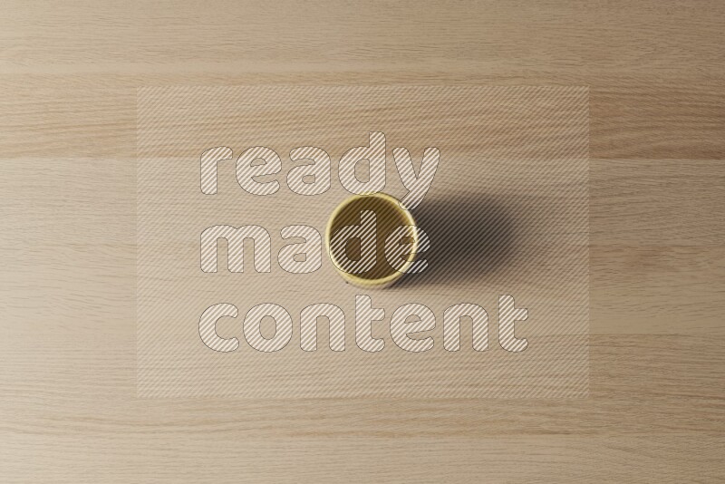 كأس فخاري متعدد الألوان على خلفية خشبية فاتحة