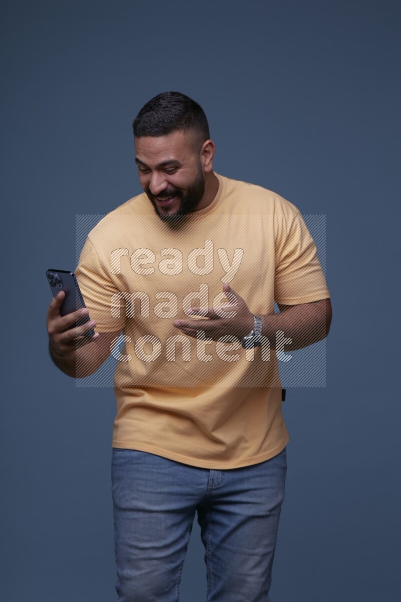 A man having a Video Calling on Blue Background wearing Orange T-shirt