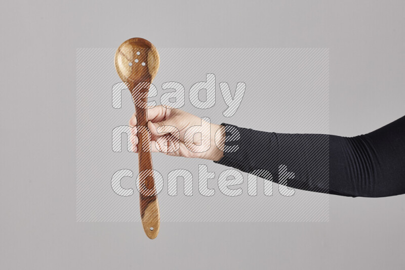 A woman in black abaya holding different wooden essentials in different positions