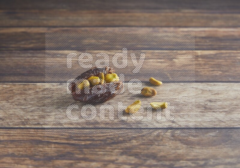 pistachio stuffed madjoul date on a wooden background