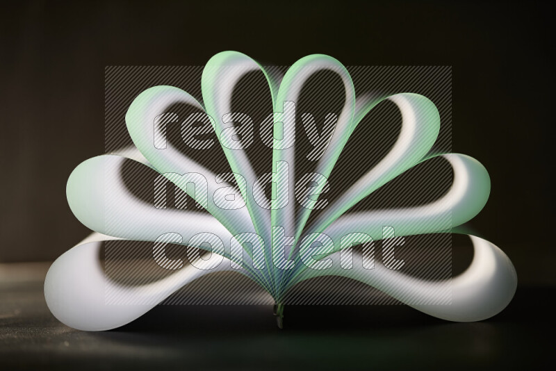 An abstract art piece displaying smooth curves in green and white gradients created by colored light