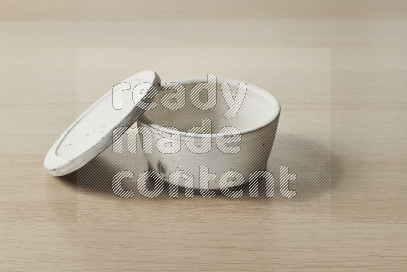A white pottery bowl on light wooden background
