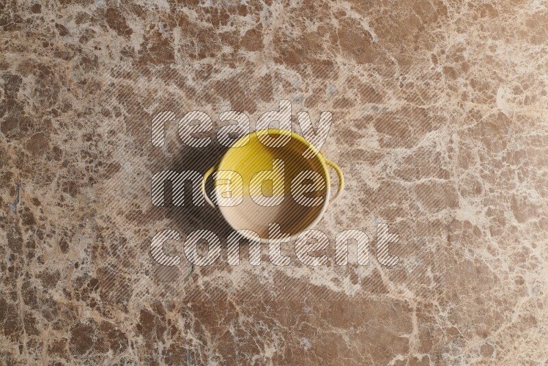 A multicolored pottery bowl on beige marble background