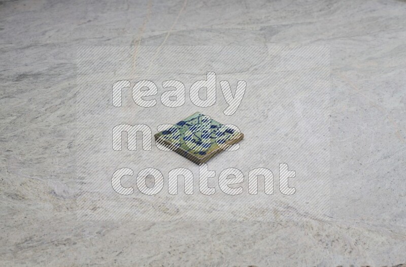 Top view shot of a pottery coaster\ tile on beige marble flooring