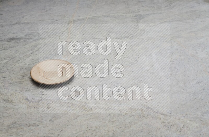A beige pottery plate on grey marble background